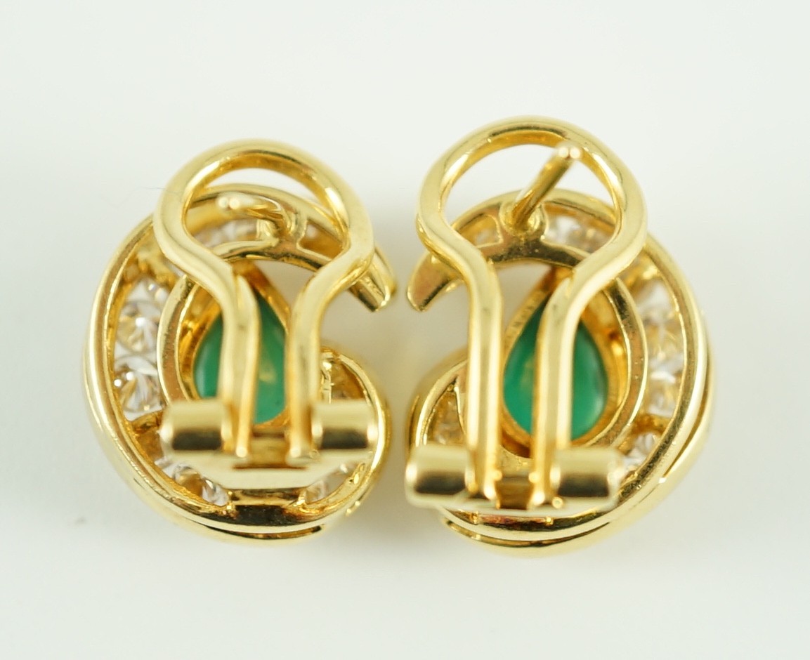 A modern pair of gold (tests as 18ct), emerald and diamond set scrolling cluster earrings